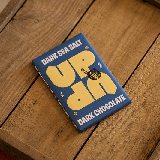 Dark Sea Salt Uppercut Dark Chocolate bar on a wooden surface
